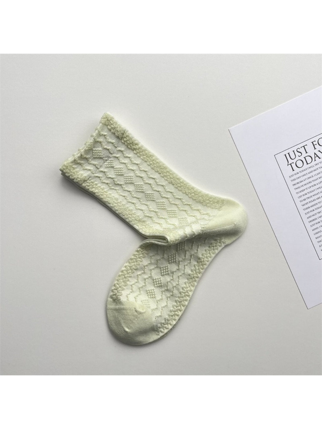 Pair of Rufia lace white mid-calf socks laid side by side highlighting lace design