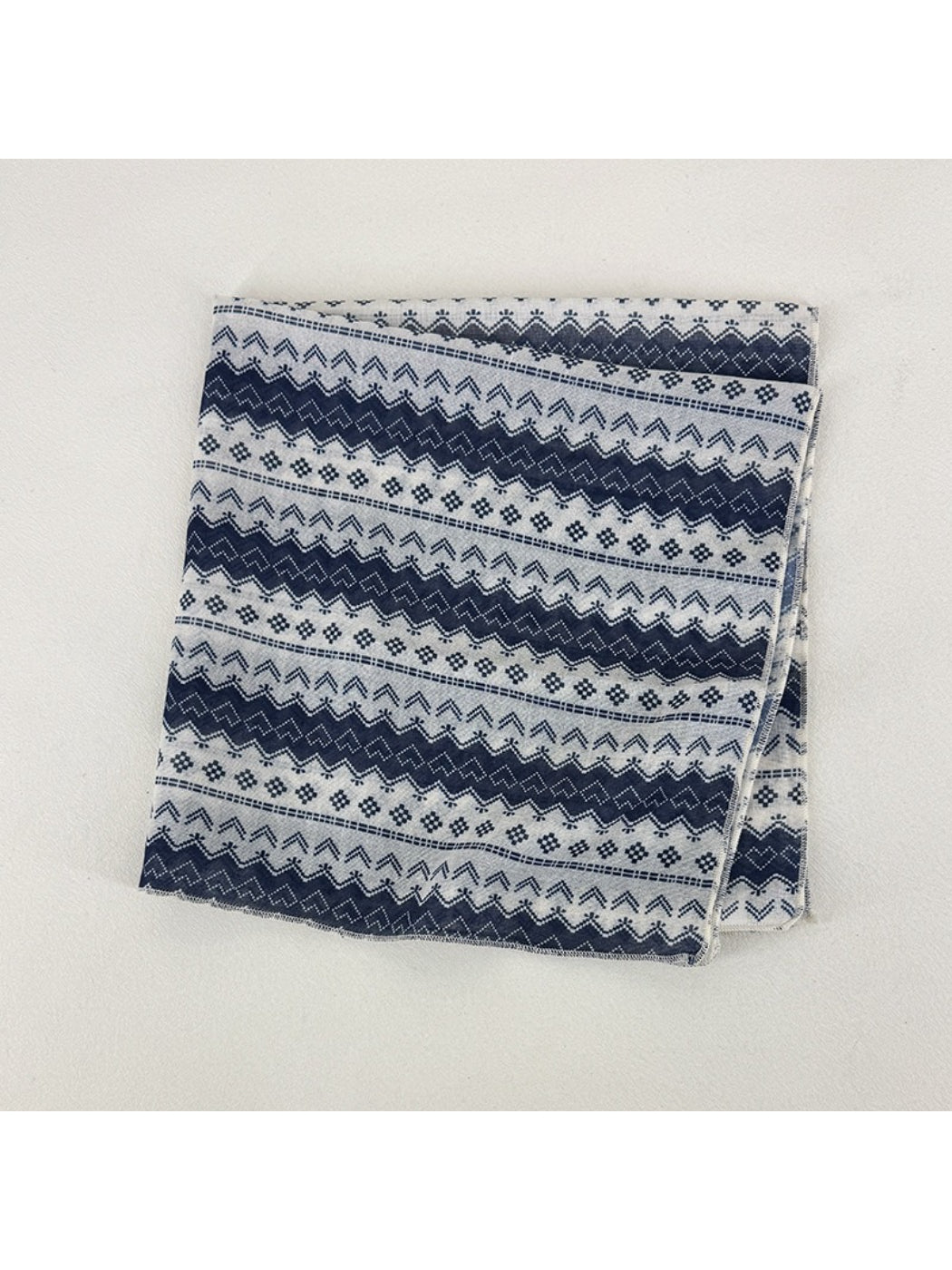 Scarvii square scarf laid flat displaying full geometric pattern in blue, beige, and white