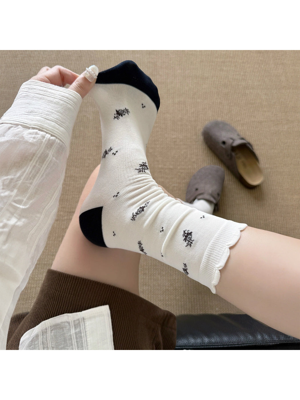 Rufia Classic Floral Knit Crew Socks displayed on wooden surface with soft light
