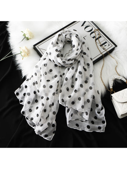 Soft lightweight scarf with black and white polka dot pattern draped on a mannequin