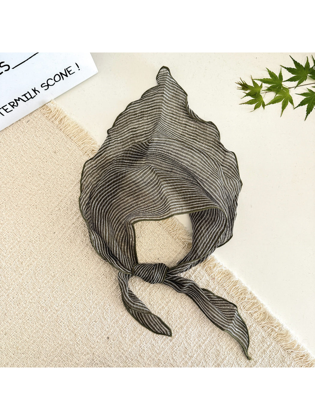 Side view of model with the soft textured stripe head scarf tied at the back