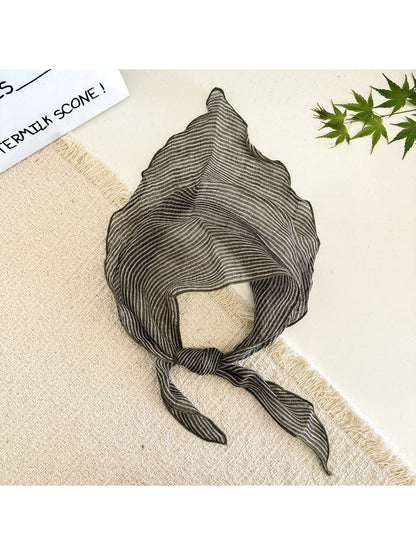 Side view of model with the soft textured stripe head scarf tied at the back