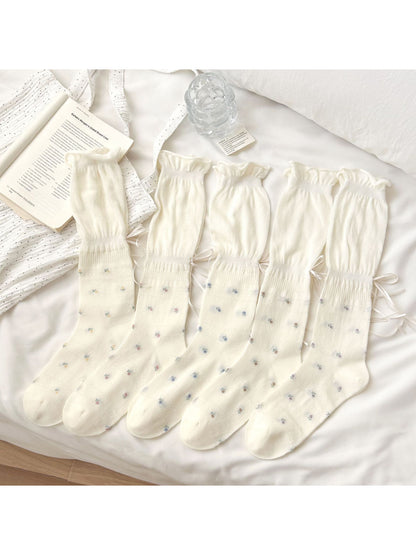 Pair of Rufia Soft Bloom Ruffle Crew Socks in pastel pink with floral pattern and ruffled top