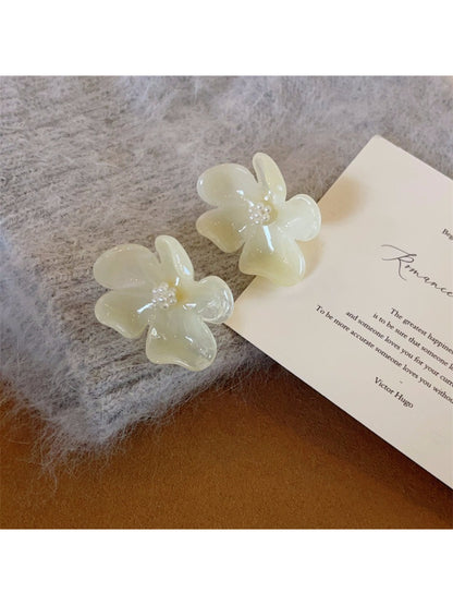 Earwish Rounded Petal Bloom Earrings arranged with green leaves for a natural look