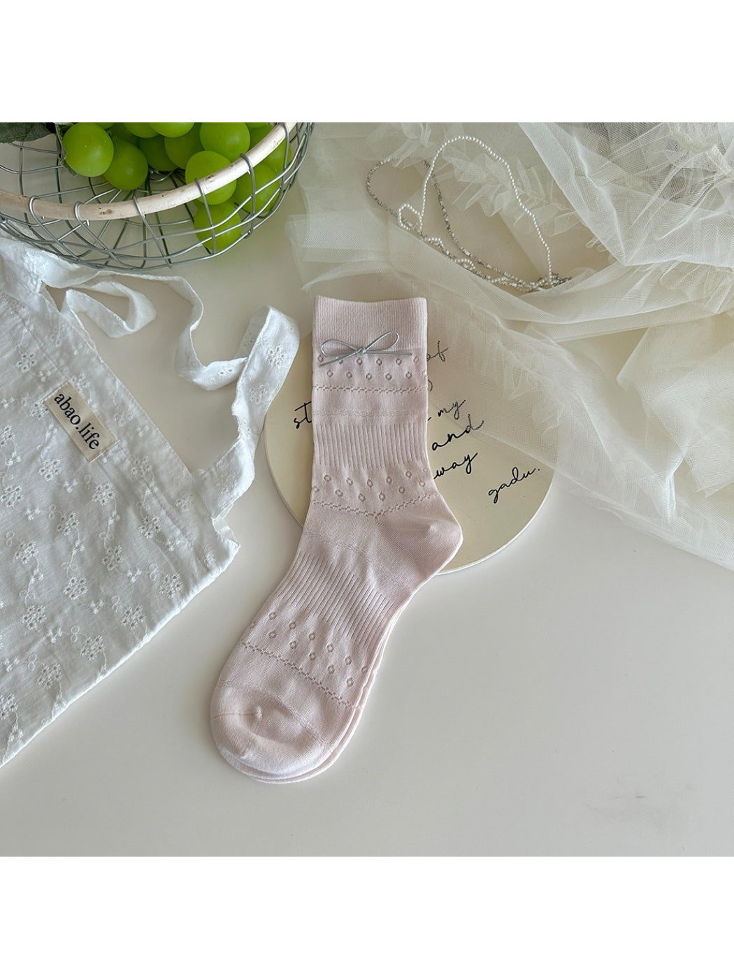 Side view of Rufia delicate bow texture socks on model's feet