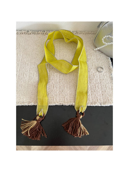 Scarvii skinny scarf with boho tassel trim displayed on wooden surface