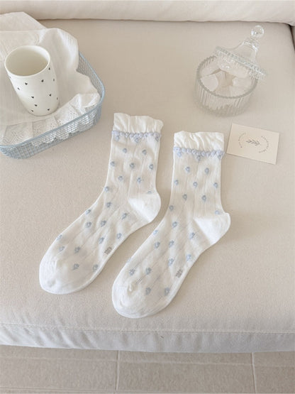 Rufia socks folded to display pink flower pattern and ruffled top detail