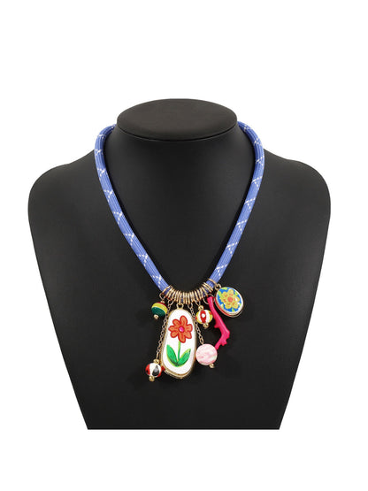 Flat lay of colourful multi charm rope necklace with vibrant beads and silver details