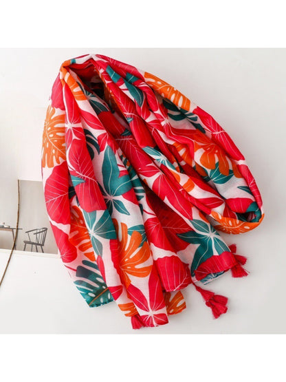 Close-up of Scarvii scarf fabric with detailed botanical leaf print in green and orange tones