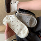 Pair of Rufia Everyday Polka Dot Socks in white with black dots displayed flat