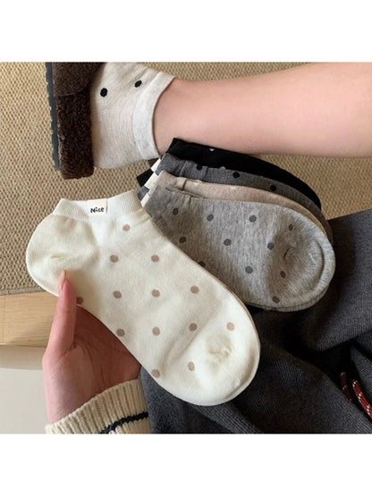 Pair of Rufia Everyday Polka Dot Socks in white with black dots displayed flat