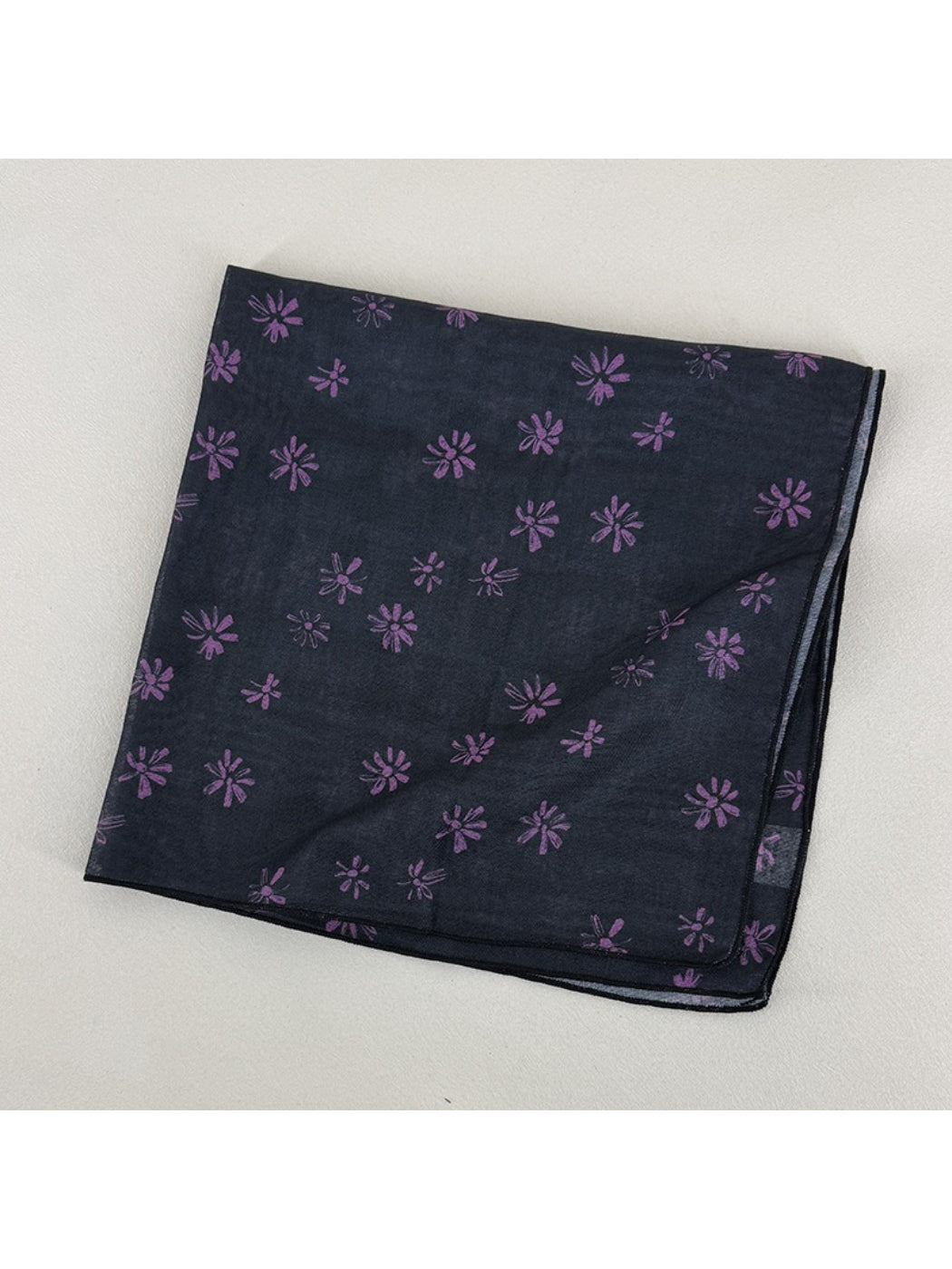 Flat lay of Scarvii square scarf fully spread showing all-over daisy floral design