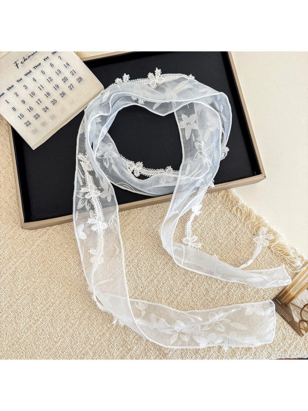 Close-up of delicate floral lace trim on sheer skinny scarf