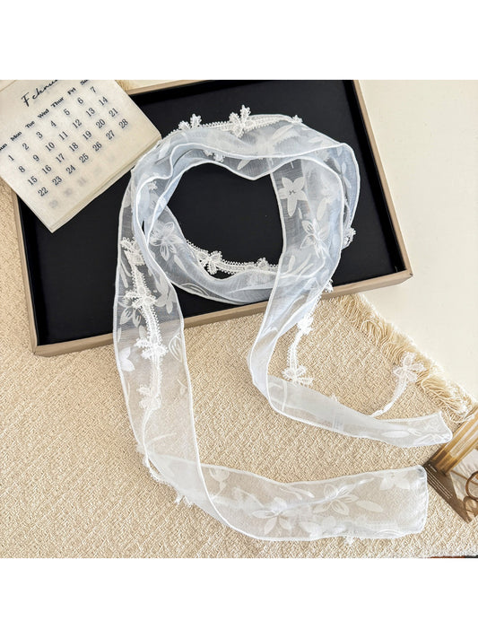 Close-up of delicate floral lace trim on sheer skinny scarf