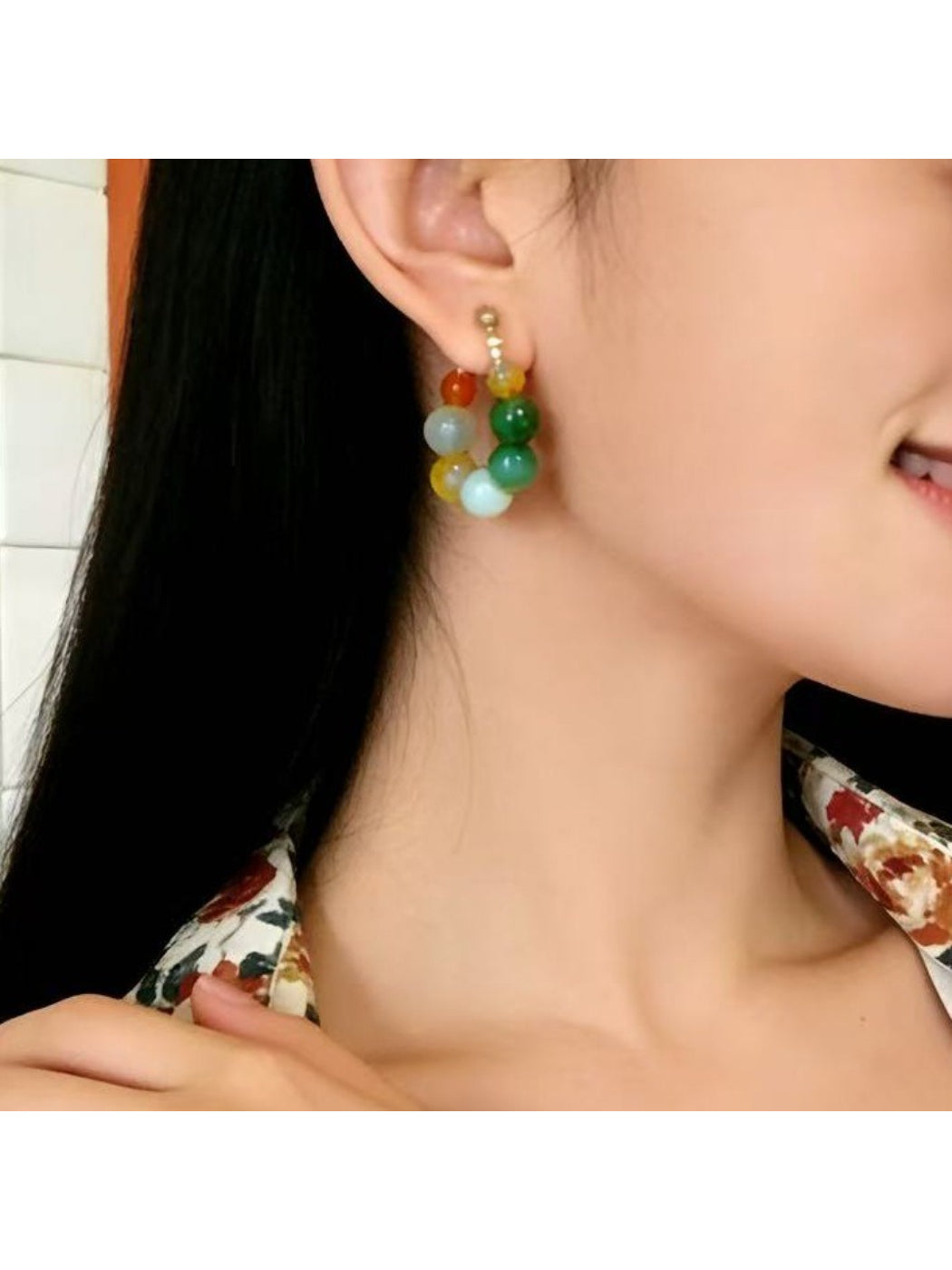 Model wearing Earwish multicolor beaded hoop earrings with colorful beads