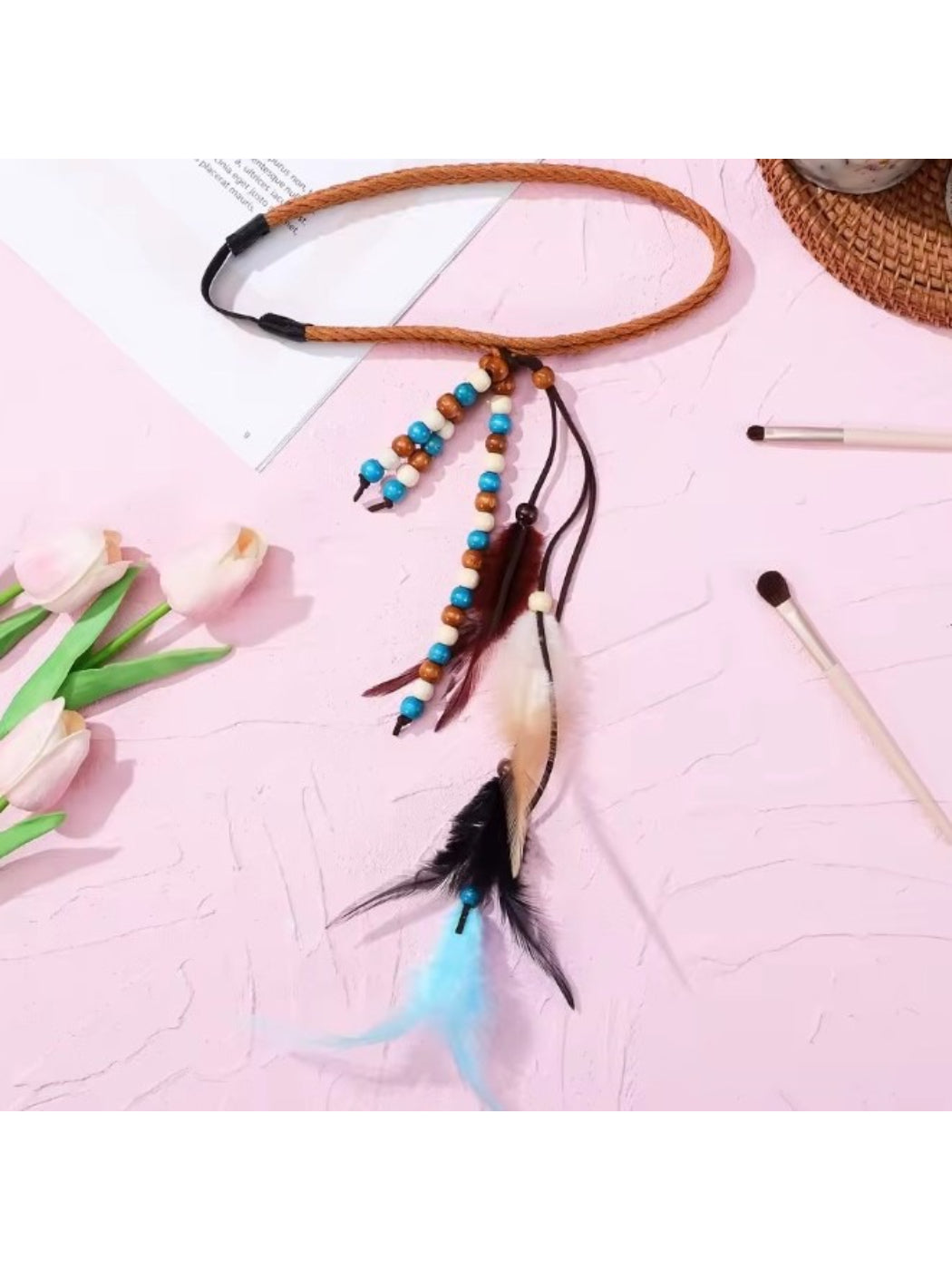 Hairish boho feather headband styled on a mannequin head with beads and feathers