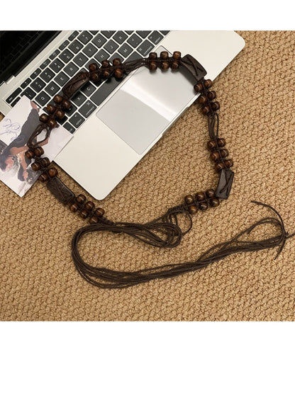 Beco brown beaded tie waist belt tied in a bow on a mannequin waist