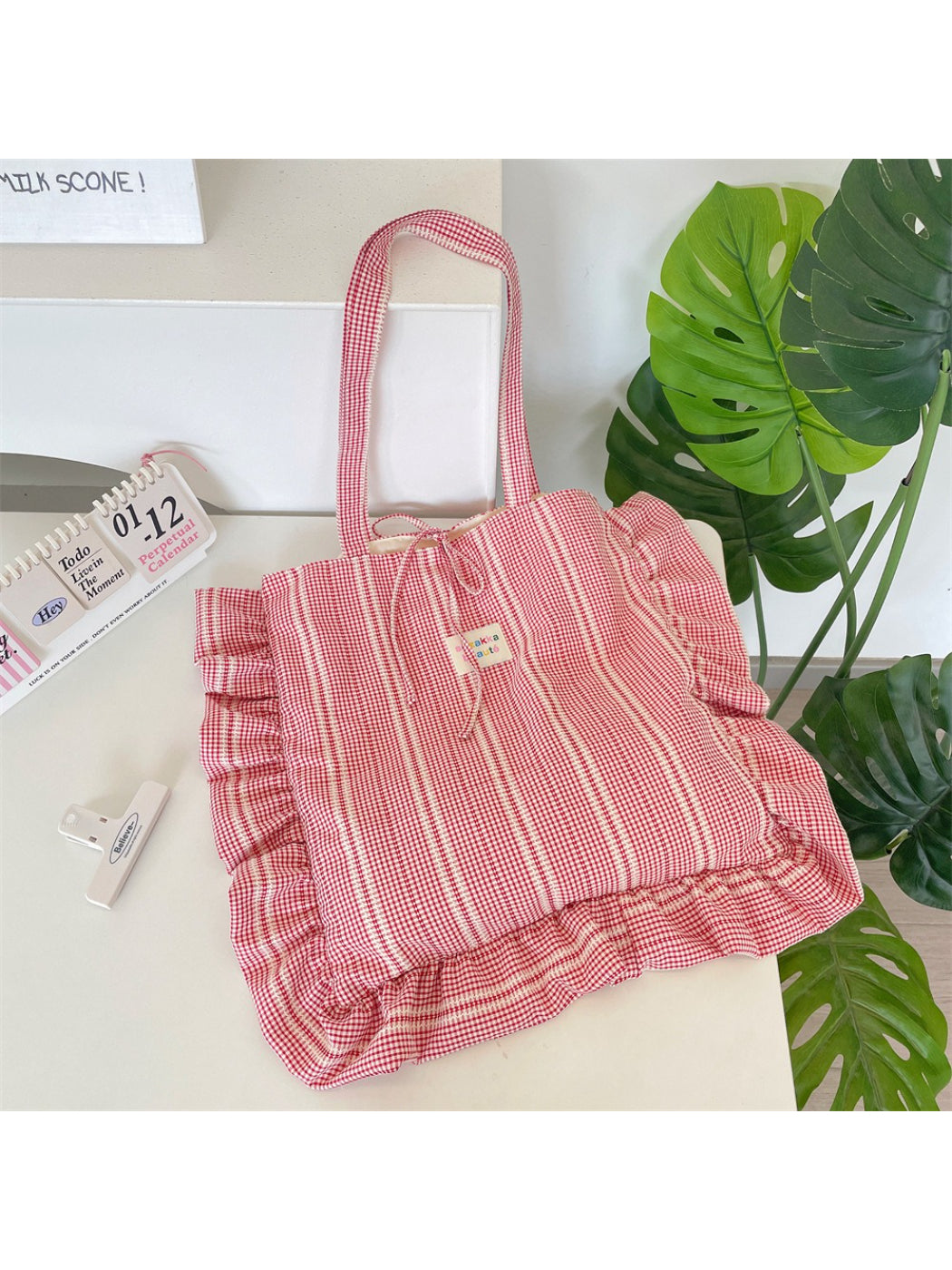 Cosbai pastel plaid shoulder tote bag hanging by its shoulder strap