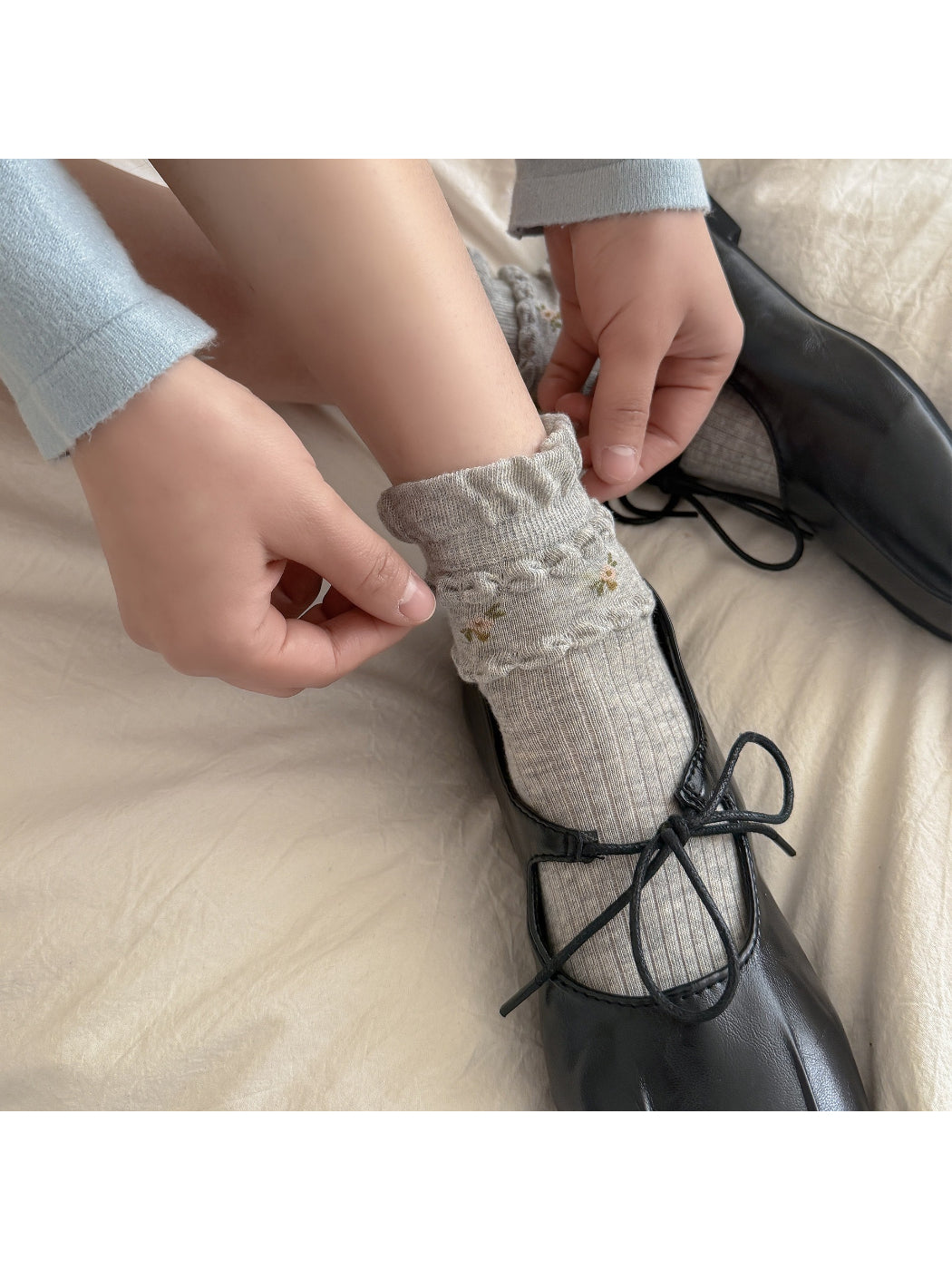 Close-up of floral embroidery on Rufia ribbed crew socks in beige