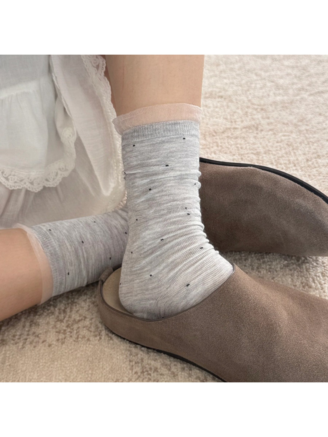 Pair of Rufia soft polka mesh socks folded neatly on a wooden surface