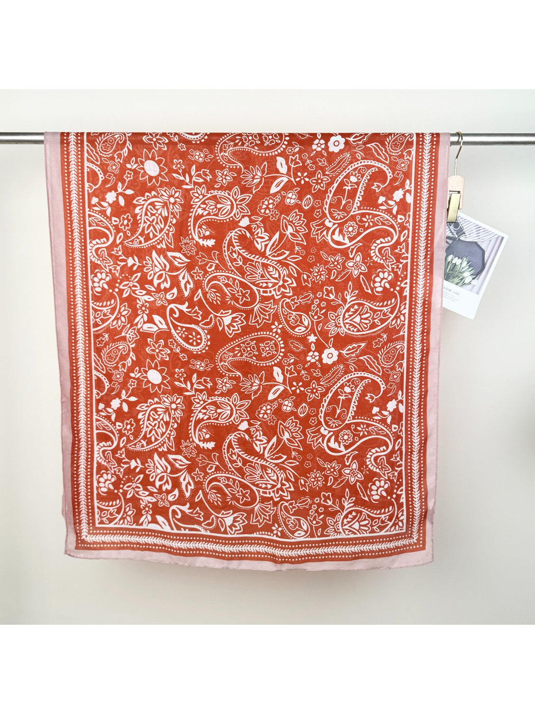 Scarvii Western Paisley Wrap Scarf styled as a shawl on a wooden hanger