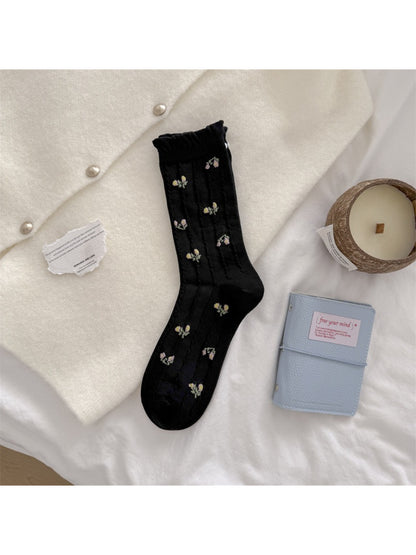 Pair of Rufia floral crew socks laid flat highlighting bead embellishments
