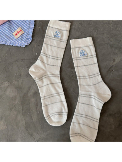 Rufia pastel stripe knit socks displayed with packaging on wooden surface