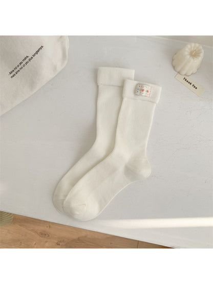 Stacked Rufia crew socks displaying multiple stripe color variations and thickness