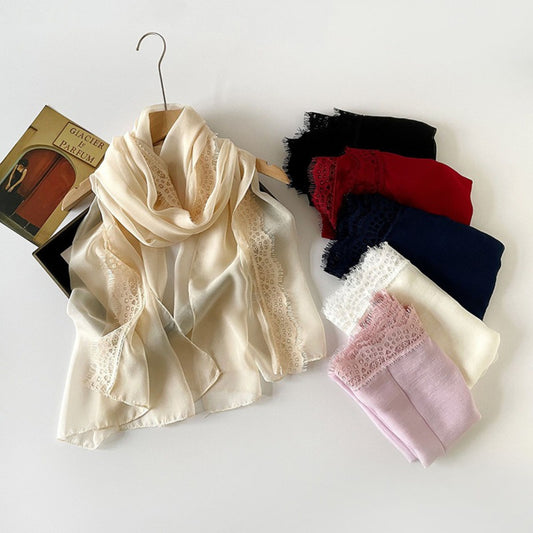 Lightweight scarf with delicate lace border draped on a white background