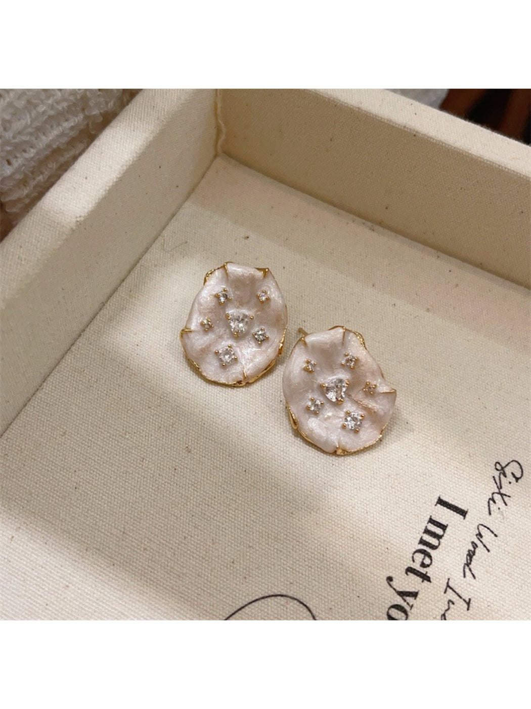 Pair of Earwish soft color floral stud earrings with gold-tone backing