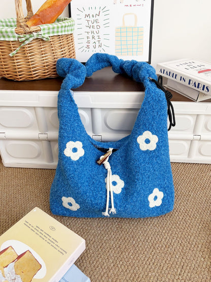 Cosbai floral knit drawstring bag held by hand showing size and shape