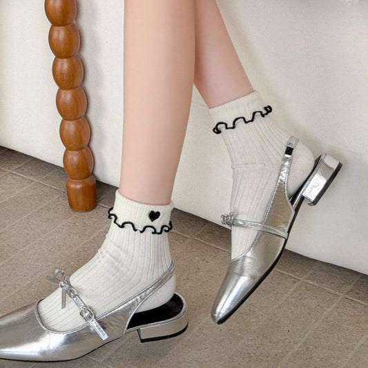 Close-up of Rufia socks showing soft fabric and ruffled lettuce edge with heart design