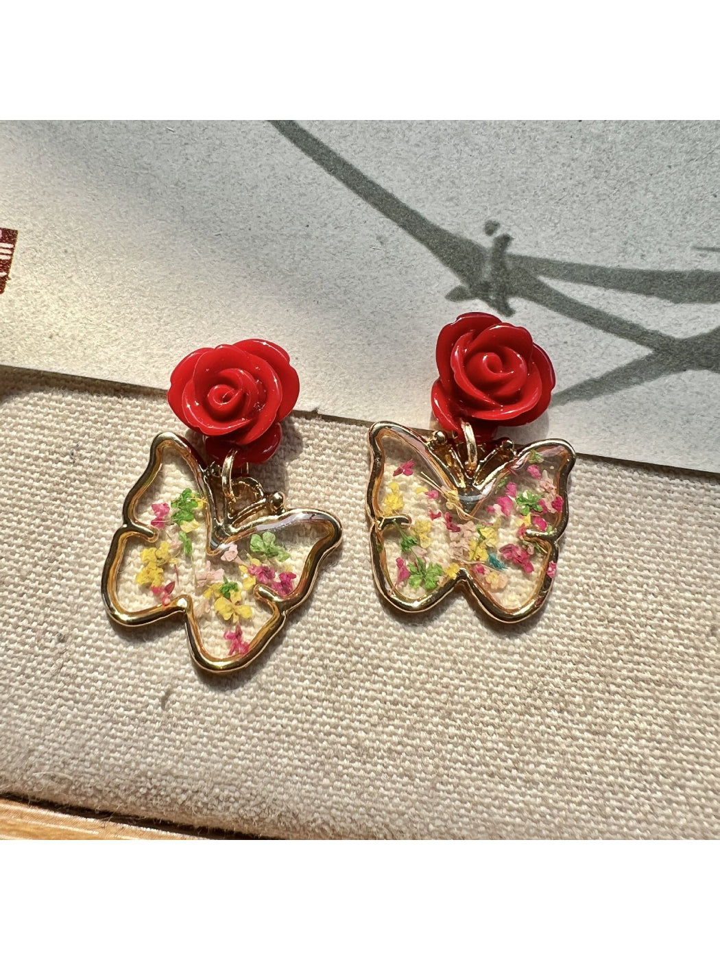 Earwish Rose Butterfly Drop Earrings displayed on white background highlighting rose and butterfly