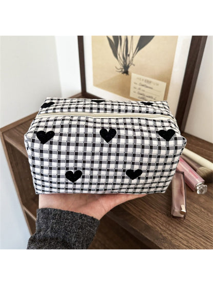 Black and white heart patterned makeup bag on a white background