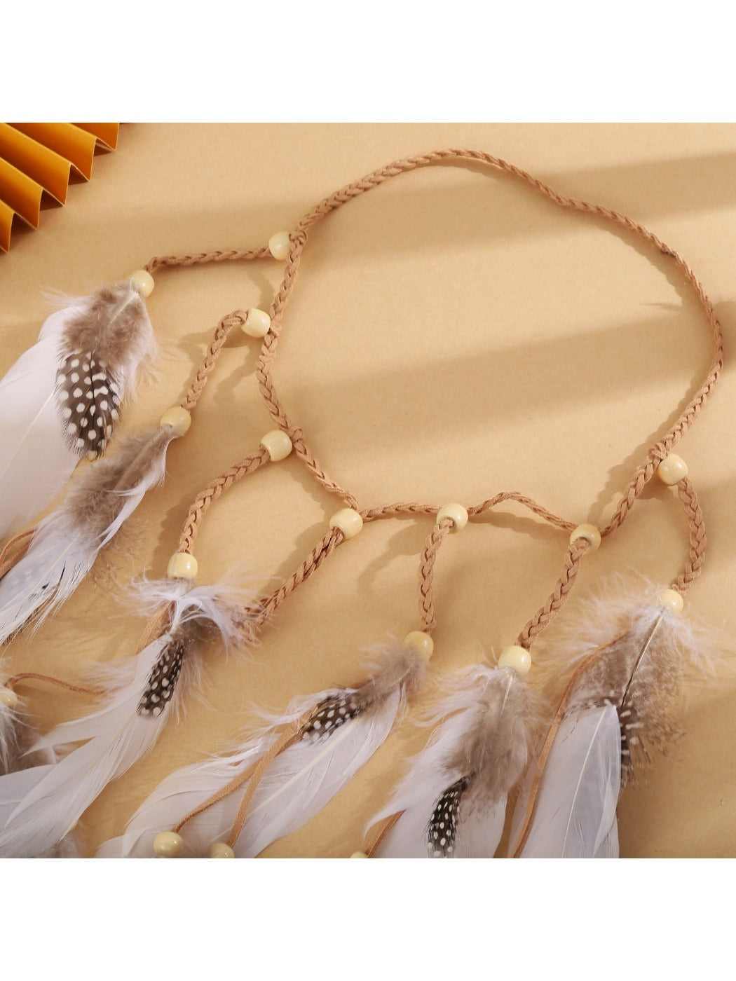 Hairish festival hair headband displayed flat showing feather and bead design
