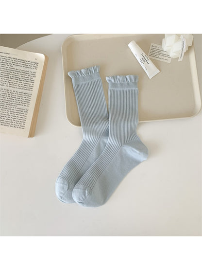 Rufia Everyday Ruffle Cuff Crew Socks paired with sneakers on wooden floor