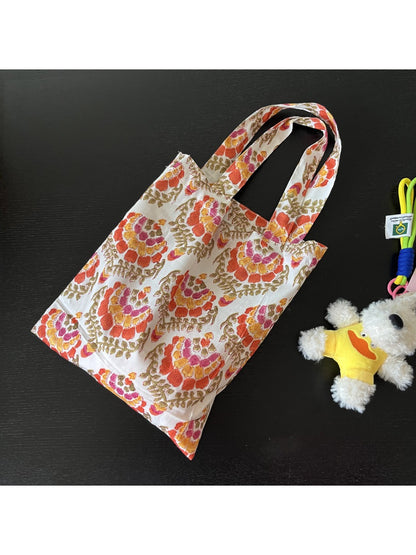 Cosbai tote bag hanging on a hook displaying full print and shape