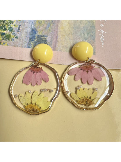 Close-up of clear floral earrings showing detailed petals and gold hooks