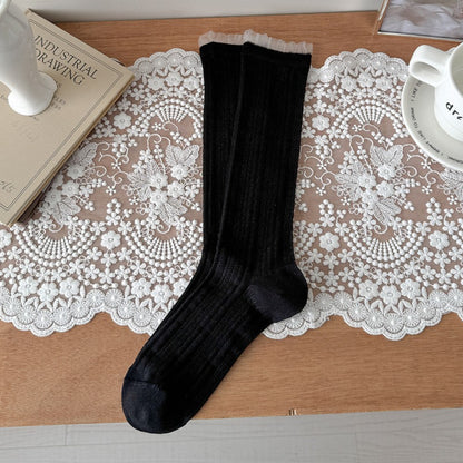 Side view of Rufia beige ribbed crew socks showing stretch and fit