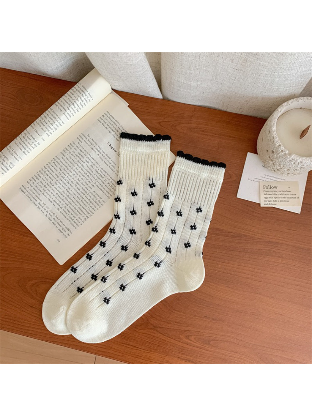 Rufia socks displayed on wooden surface emphasizing texture and floral detail