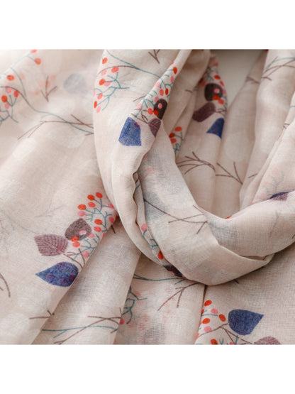 Scarf laid flat showing detailed floral and leaf motifs in soft colors