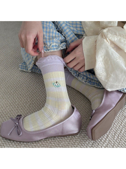 Side view of Rufia embroidered lace mesh mid-calf socks on a mannequin leg