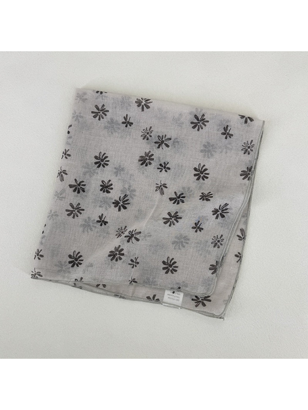 Scarvii scarf styled as headband with ditsy daisy pattern on model