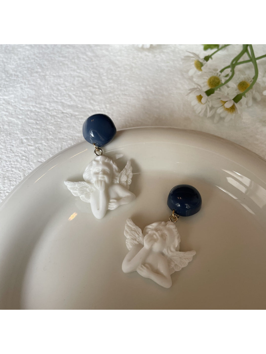 Earwish Angel Charm Drop Earrings displayed on white jewelry stand
