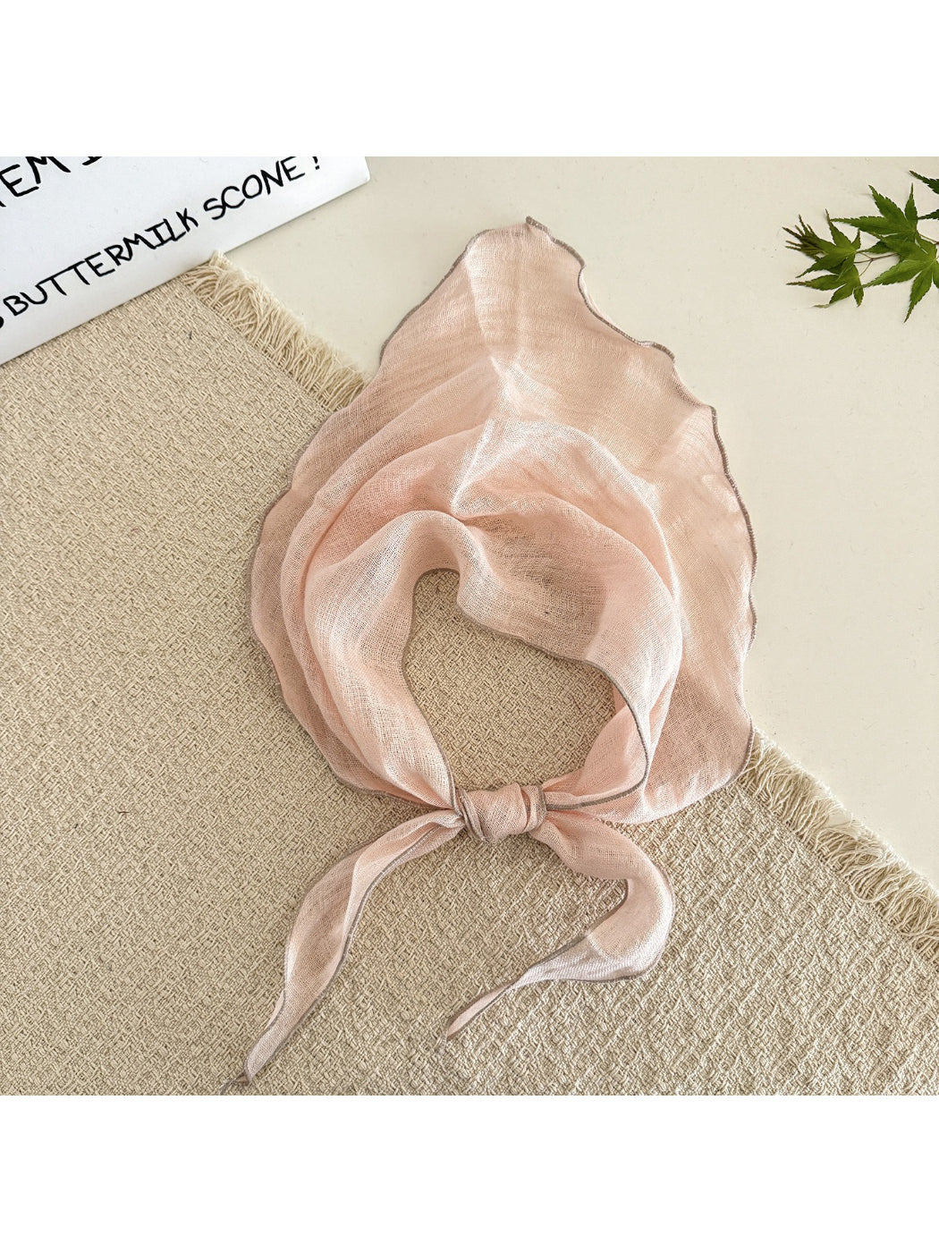 Triangle scarf folded to show its lightweight and translucent material