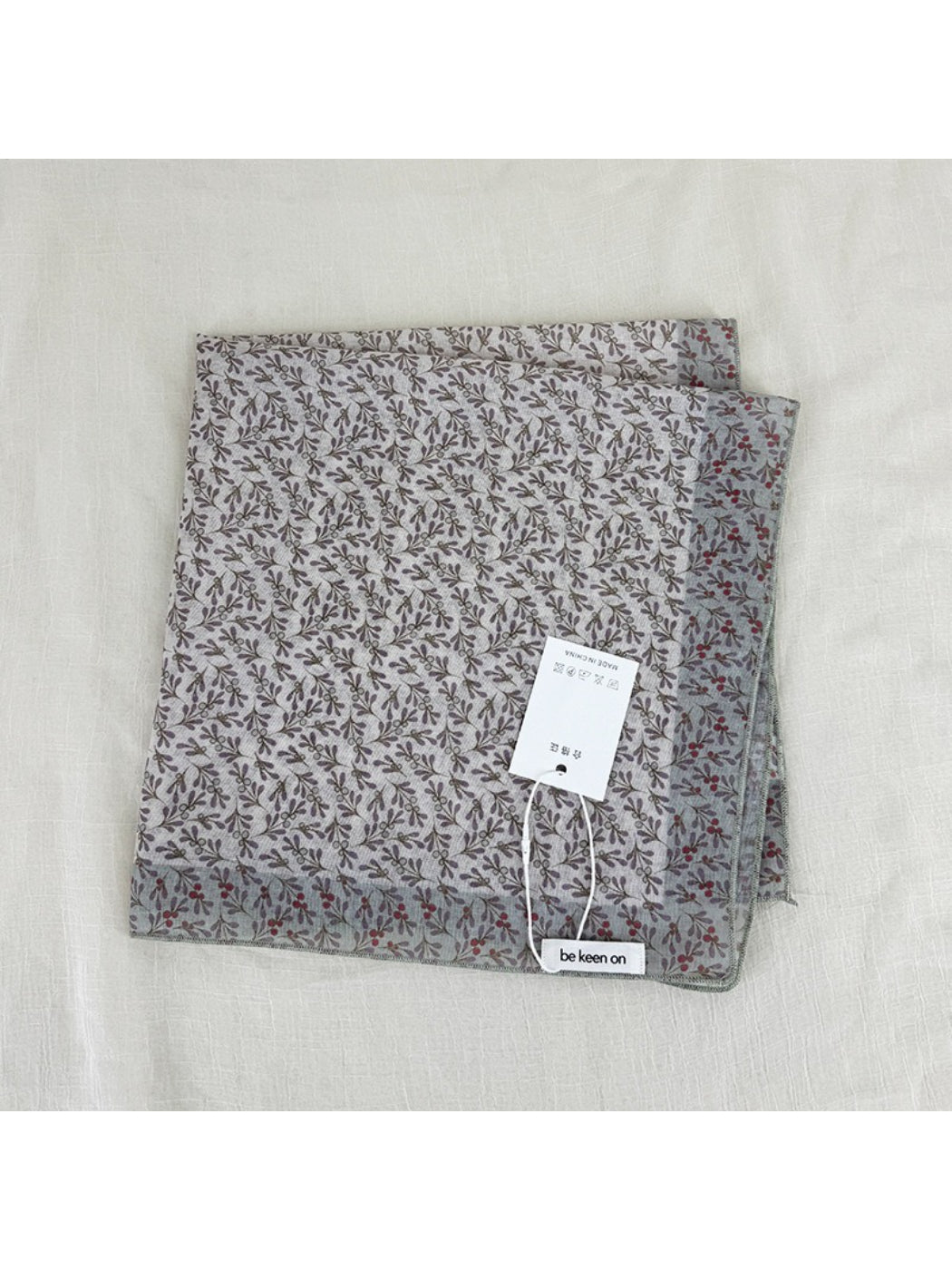 Scarvii scarf worn as headscarf highlighting floral border and soft fabric texture