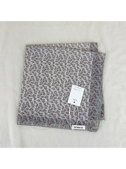 Scarvii scarf worn as headscarf highlighting floral border and soft fabric texture