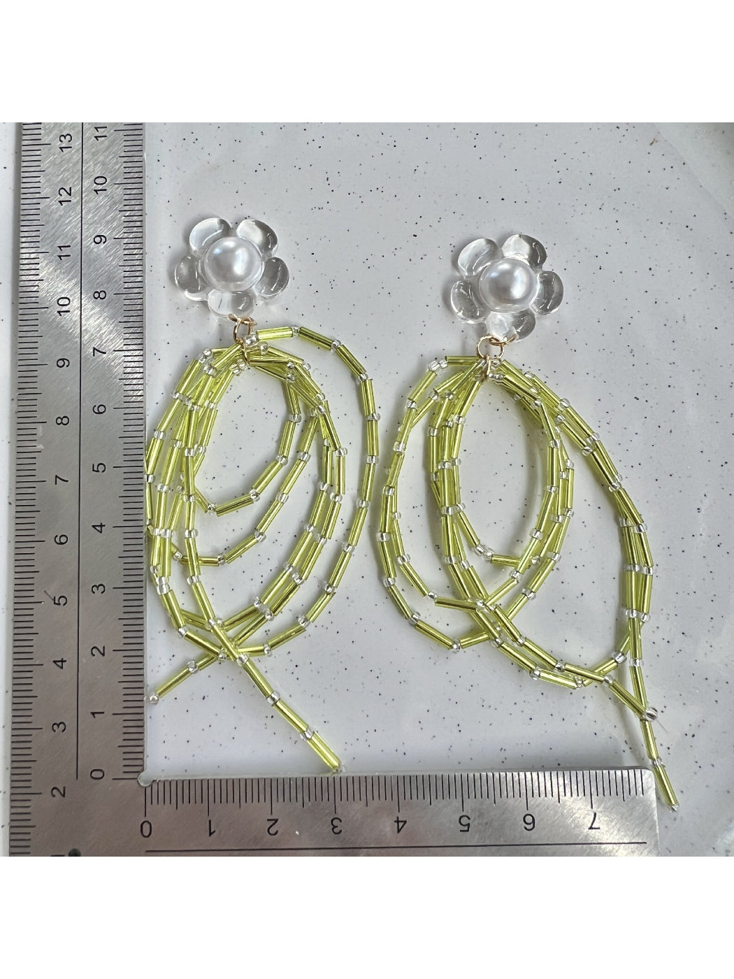 Side view of Earwish green bead dangle earrings showing bead details and silver hooks