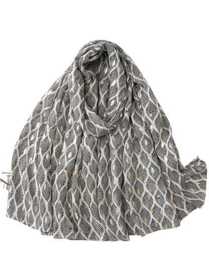 Scarf wrapped around the shoulders of a mannequin highlighting feather print and softness