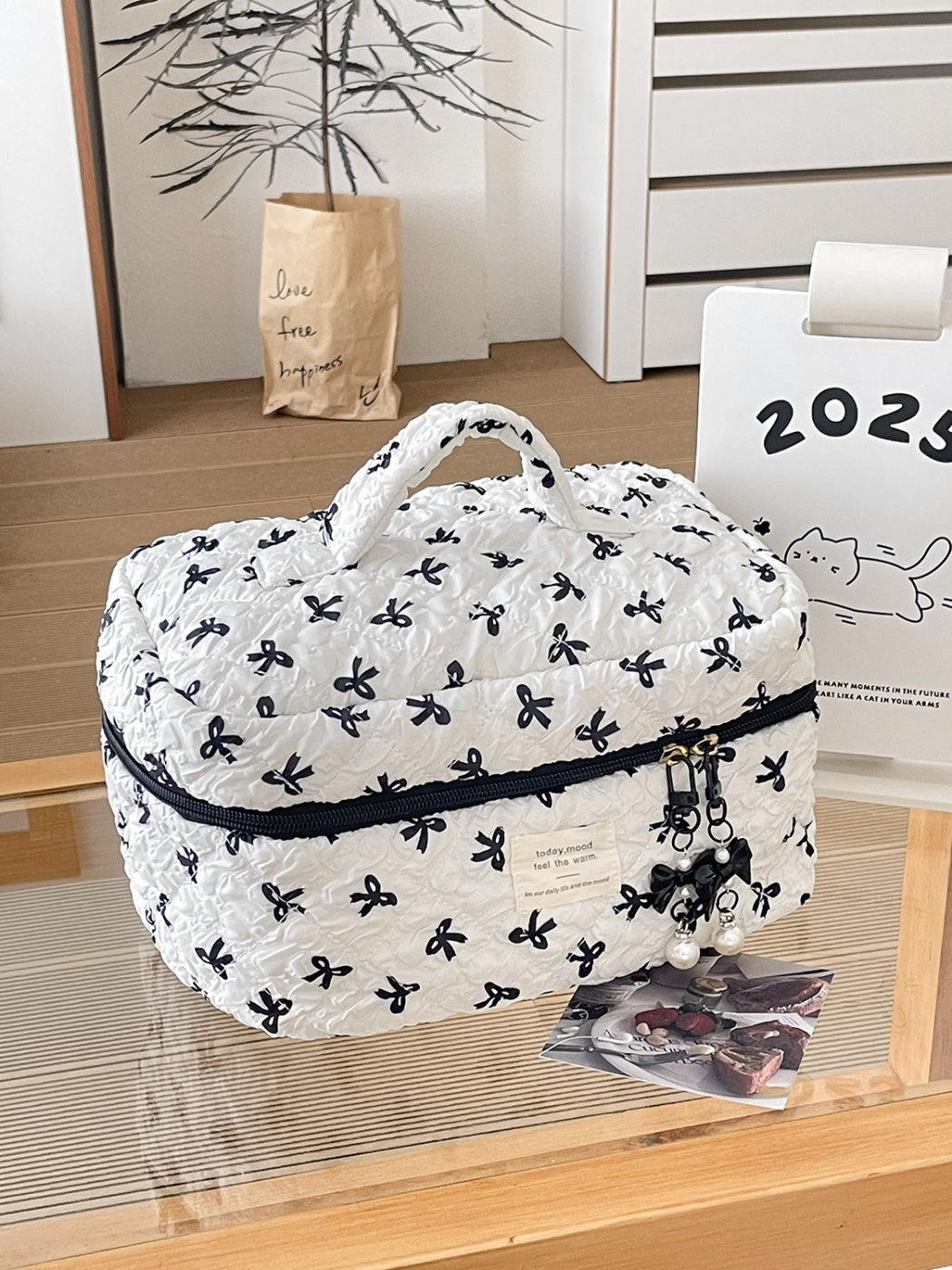 Side view of Cosbai travel makeup bag highlighting compact size and bow print design